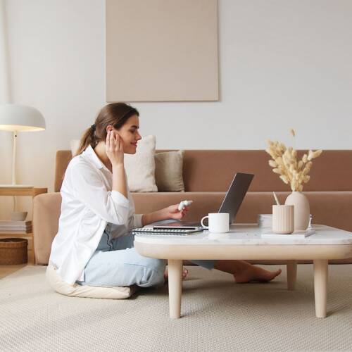 Woman on a video call with her laptop in a calm, light Scandinavian living room