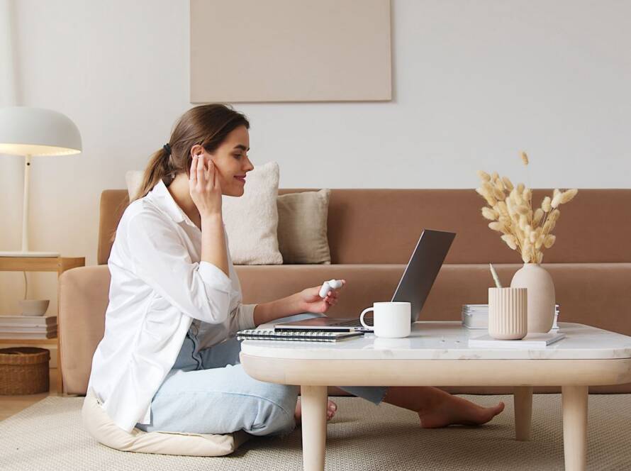 Woman on a video call with her laptop in a calm, light Scandinavian living room